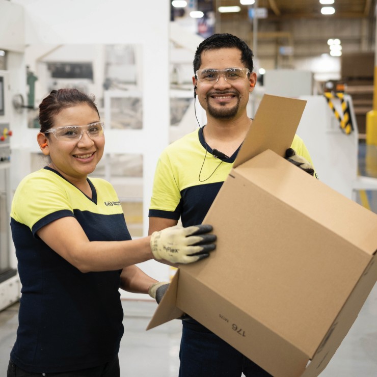 Smurfit Westrock employees holding a corrugated box